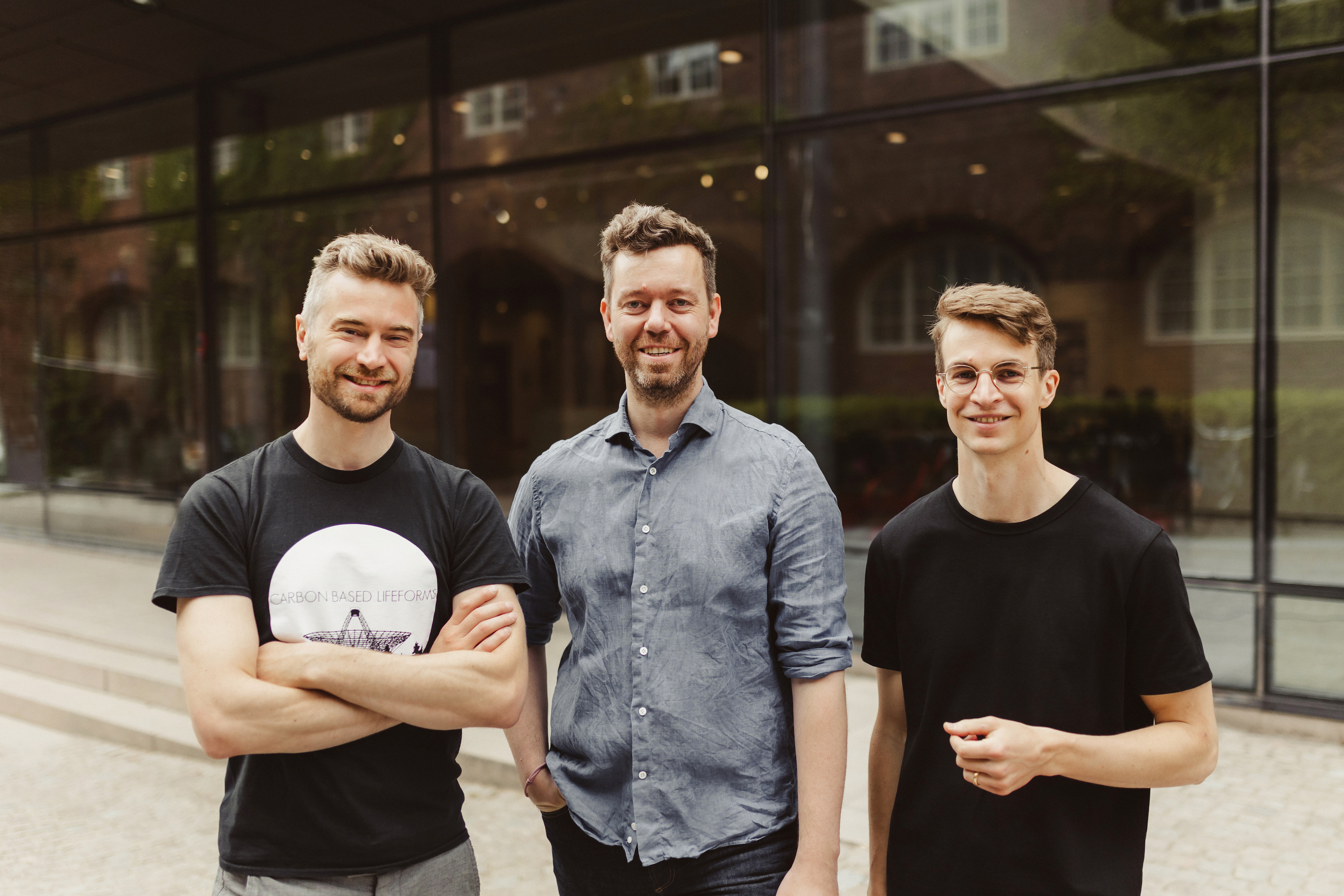 Three smiling men posing for a portrait